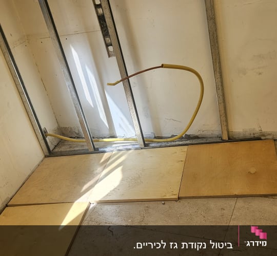 קיר עם מסגרת מתכת וצינור צהוב חשוף